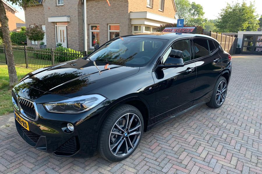 De zwarte BMW X2 lesauto van Autorijschool Mulders schuin van voren